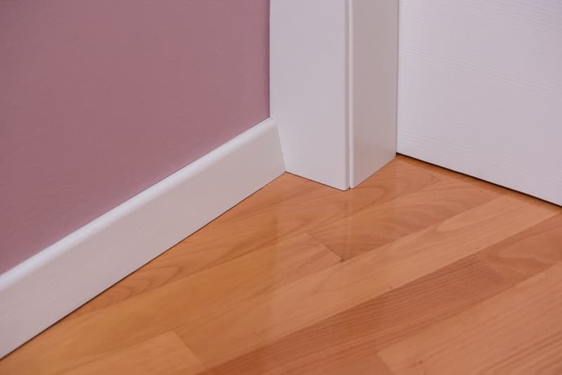 Detalj bijelog dovratnika i podne letve uz drveni pod